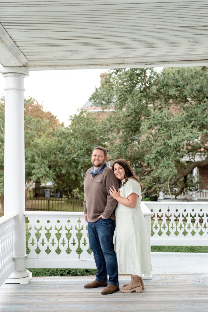 Woman standing behind man posing for engagement photos