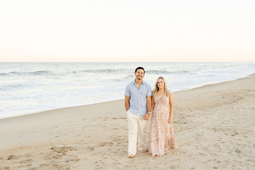 Couple sharing baby news during golden hour session at Virginia beach