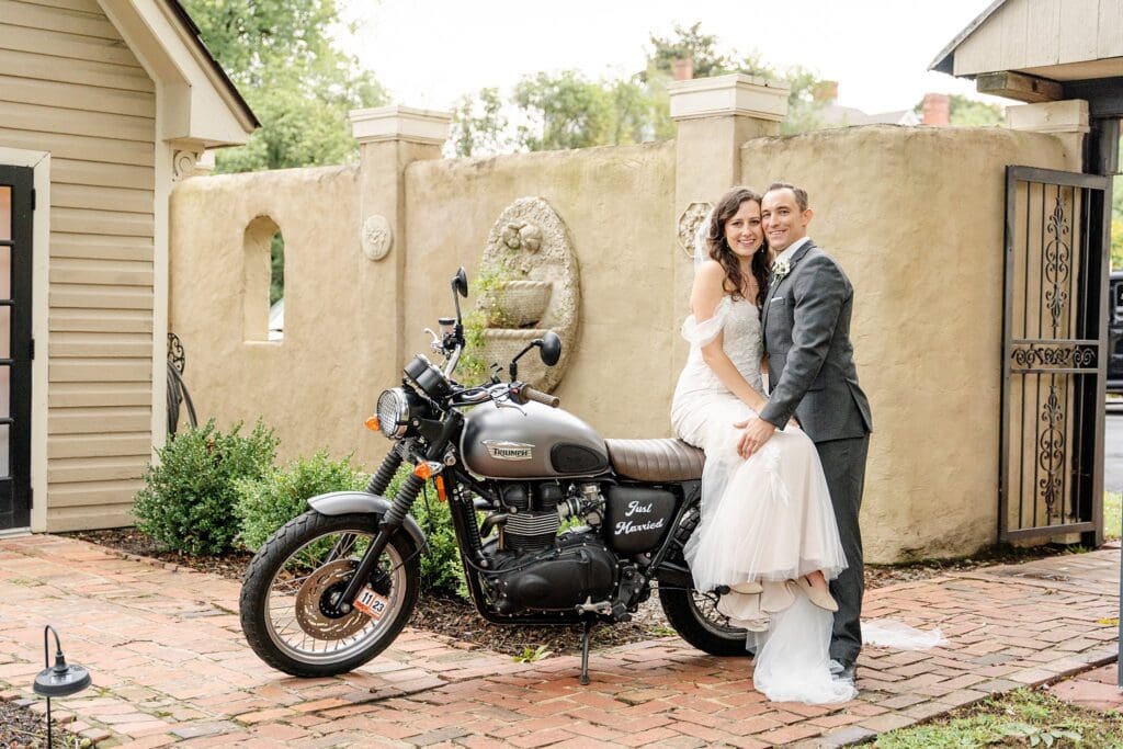 Bride and groom sitting on a motorcycle in wedding attire
