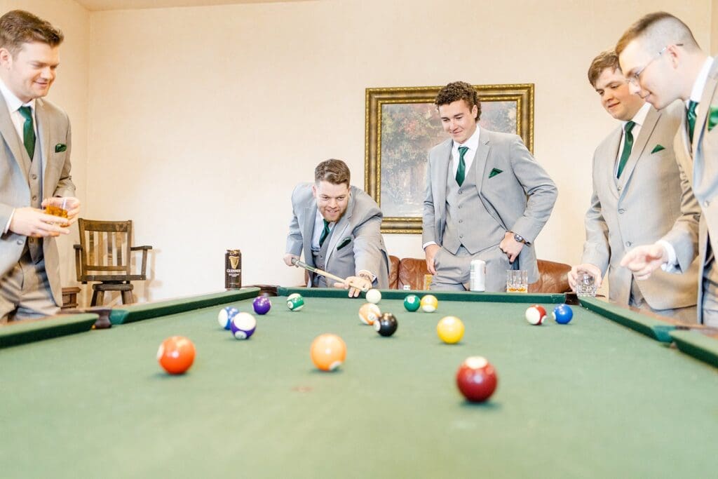 Groom and groomsmen playing pool before ceremony at Great Marsh Estate