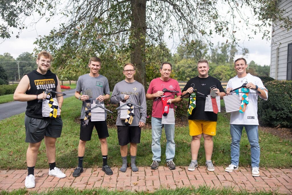 Groomsmen in sports jerseys and custom socks showing off their favorite teams