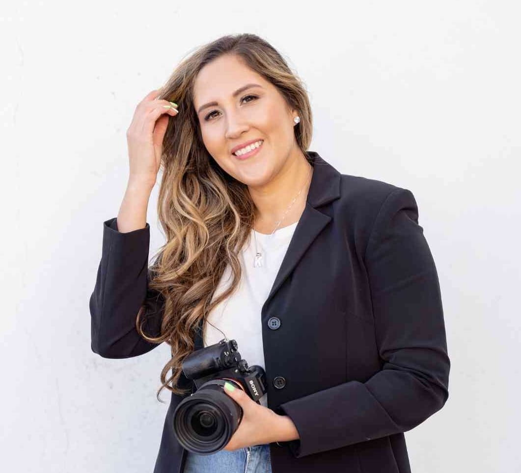 Klarissa holding camera in black coat