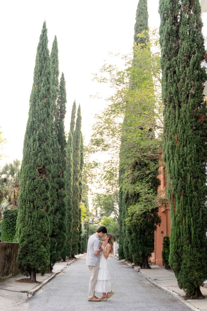 Couple hugging in alley surrounded by trees