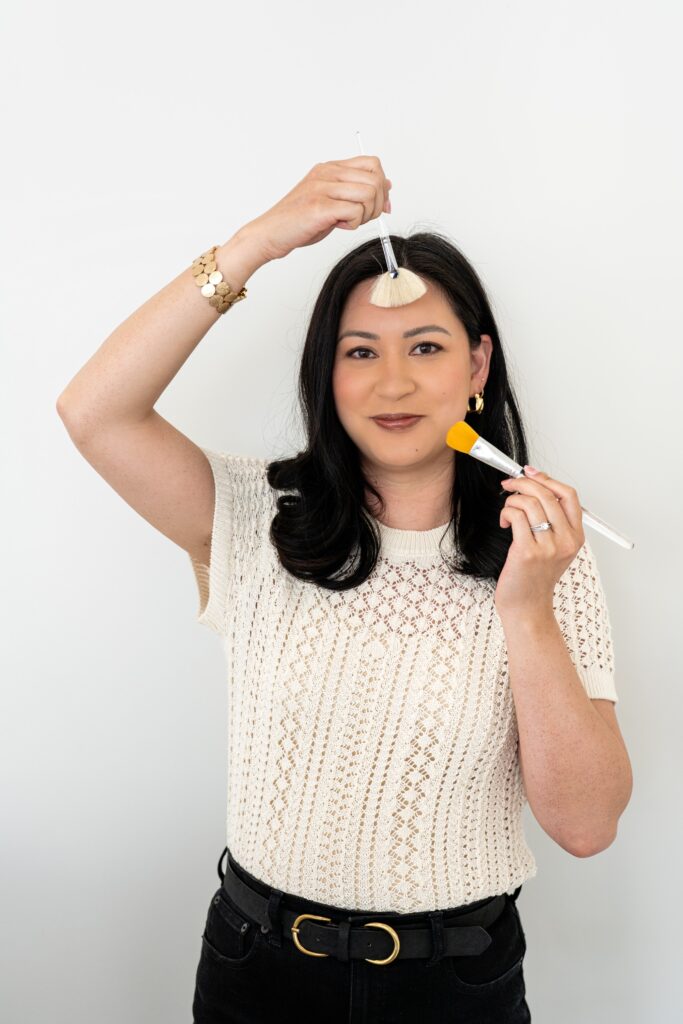 Esthetician holding face brushes
