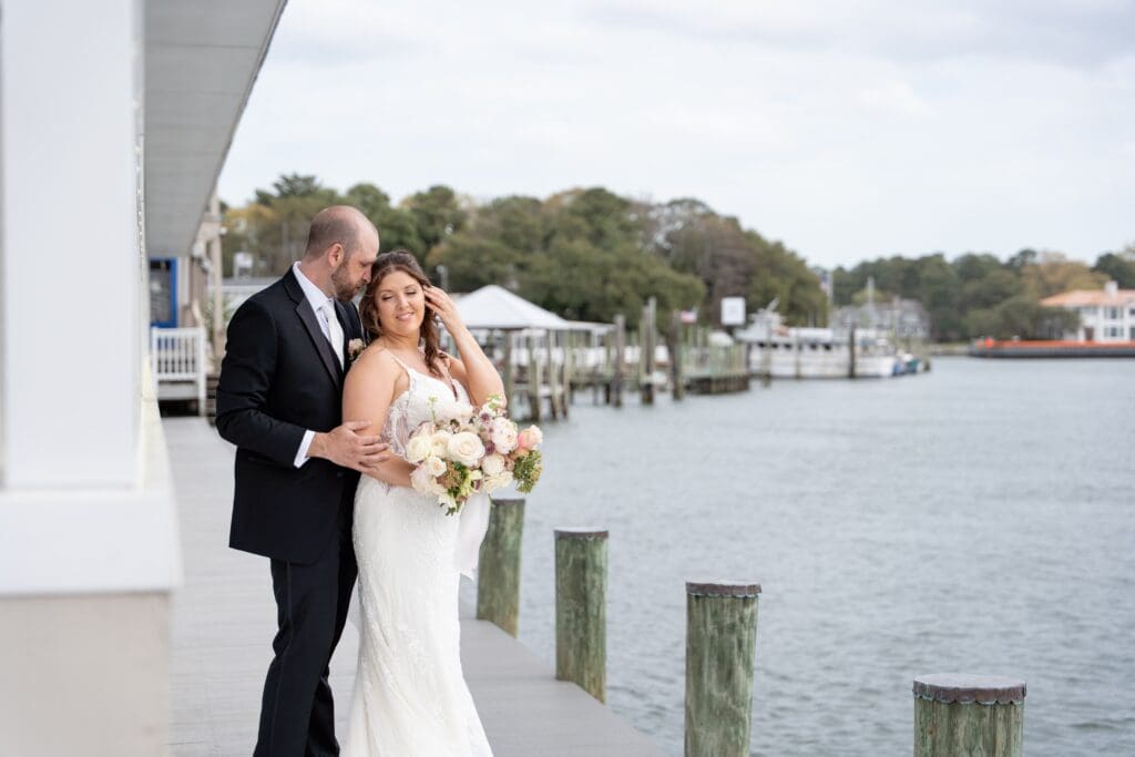 Bride and groom standing by water at Lesner Inn wedding venue in Virginia Beach