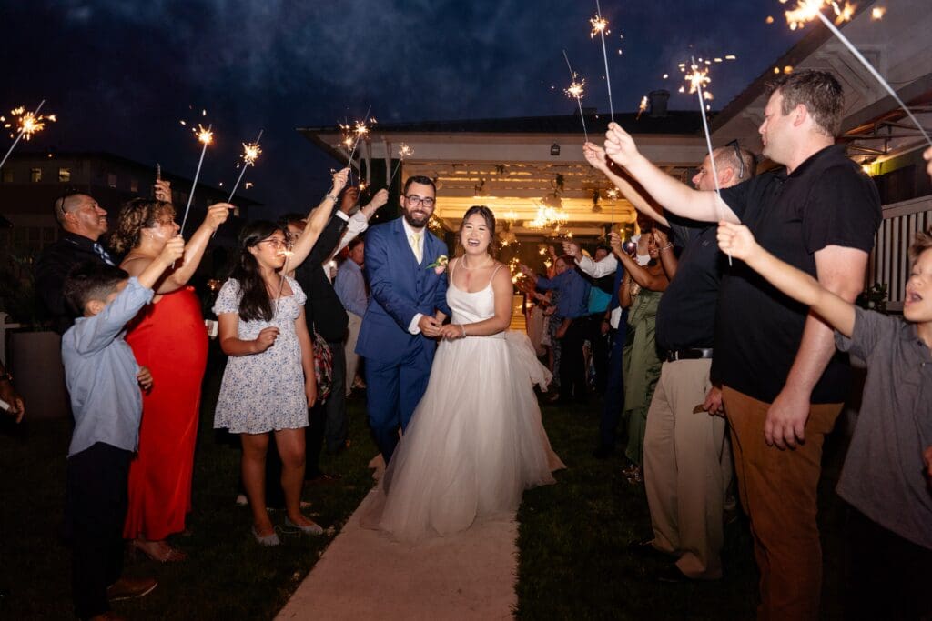 Bride and groom leaving wedding surrounded by guests
