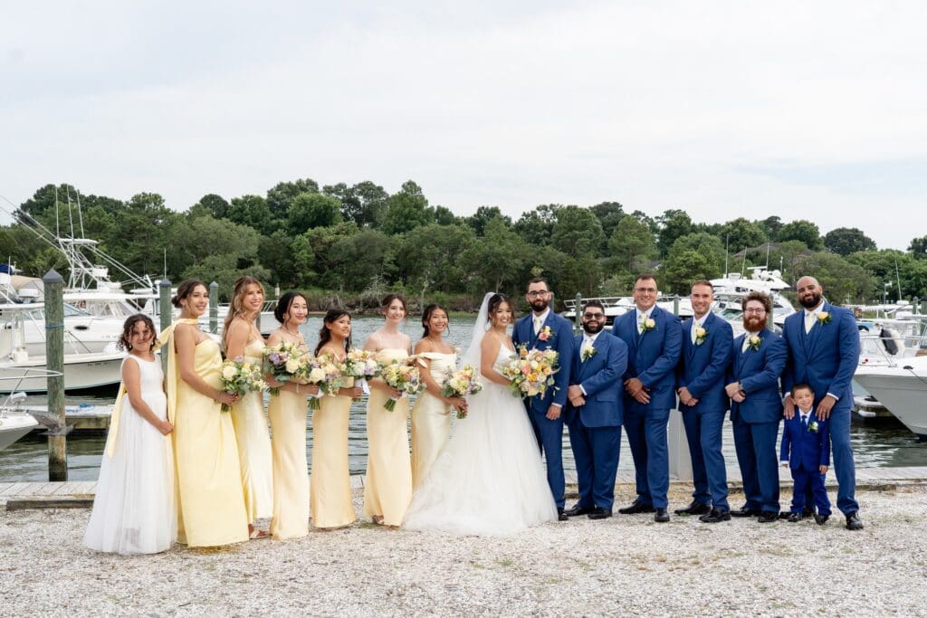 Wedding party standing in front of water